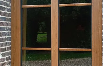 Fenêtre PVC imitation bois vue extérieure, montants fins et vitrage laissant entrer la lumière naturelle