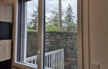 Fenêtre PVC installée dans salon, ouverture sur jardin avec vitrage clair et isolation renforcée