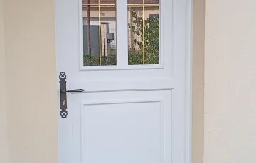 Porte d’entrée PVC blanche avec vitrage supérieur, design sobre et lumineux pour maison individuelle